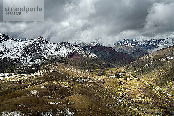 Panoramablick auf ein Tal inmitten hoher Andenberge auf dem Rainbow Mountain Trail  Pitumarca  Peru