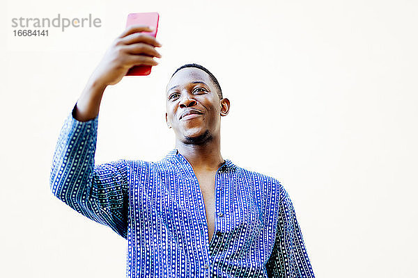 junger afrikanischer Mann macht ein Selfie mit seinem Smartphone