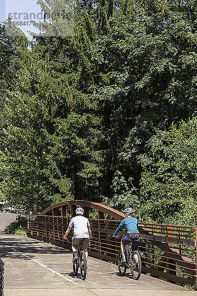 Ein junges Paar fährt mit dem Fahrrad auf einem Wanderweg in der Nähe von Troutdale  Oregon.