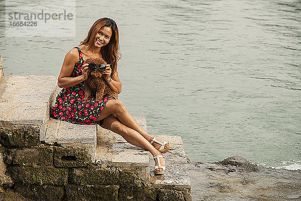 schöne Frau mit ihrem Hund am Ufer des Flusses Li in Yangshuo