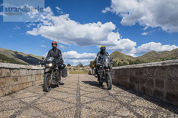 Motorräder fahren über eine Brücke des Urubamba-Flusses  Peru