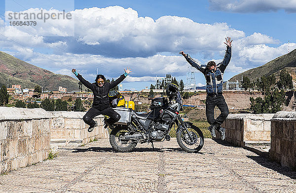 Feiernde Motorradfahrer auf der Brücke über den Urubamba-Fluss  Peru