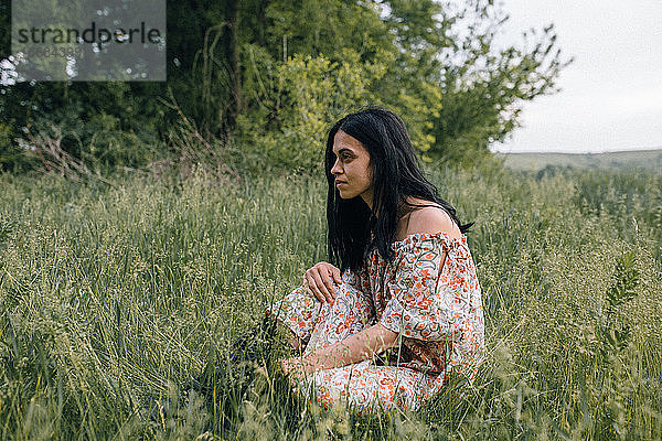 Porträt einer Frau allein auf einem Feld  die nachdenkt