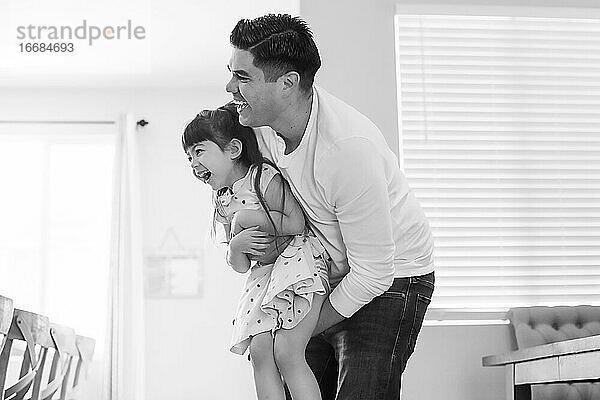 Schwarz-Weiß-Foto von Vater und Tochter  beide lachend.