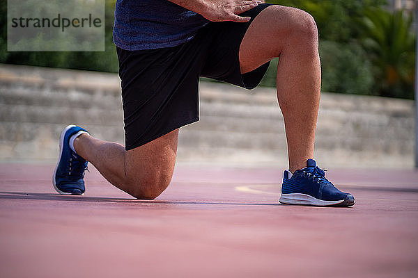 Detail eines Mannes  der seine Beine mit Power-Lunges in einem Park im Freien trainiert