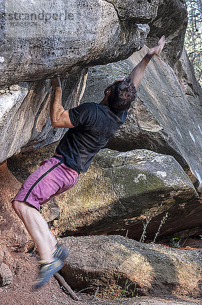 Kletterer versucht  den Felsen zu erklimmen