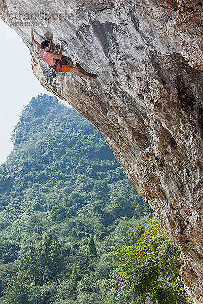 Mann beim Klettern in Odin's Den in Yangshuo  einem Klettermekka in China