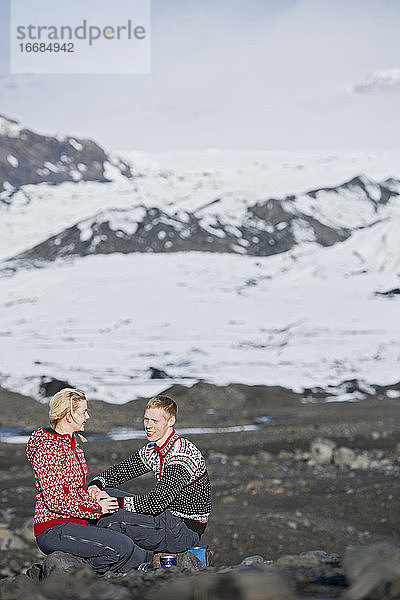 junges Paar beim Picknick in karger Landschaft in Island