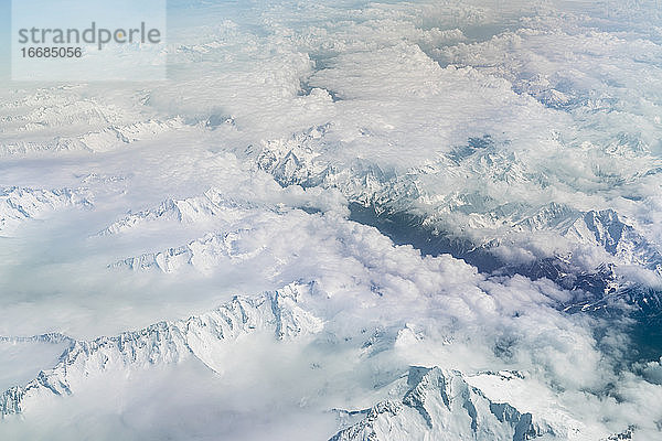 Luftaufnahme der schneebedeckten Alpen aus dem Flugzeug