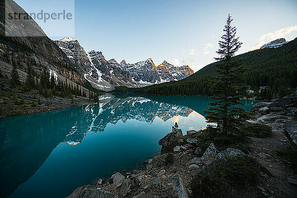 Ein Wanderer genießt den Sonnenuntergang in den kanadischen Rockies am Moraine Lake in Banff