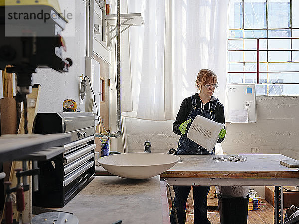 Professionelle Bildhauerin bei der Arbeit in ihrem Atelier