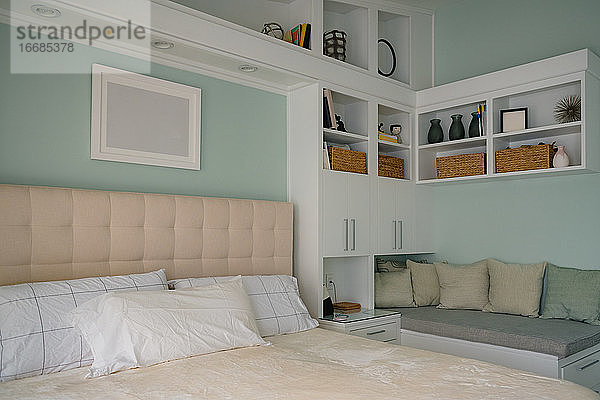 Sauberes  modernes Schlafzimmer mit Regalen und Leseeckenbank