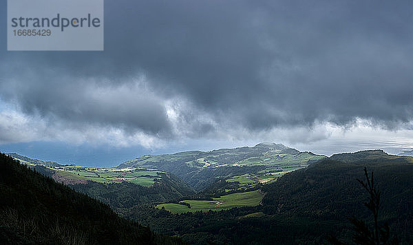 Blick aus der Wolkenhöhe auf einen grünlichen Berg in Sao Miguel  Azoren