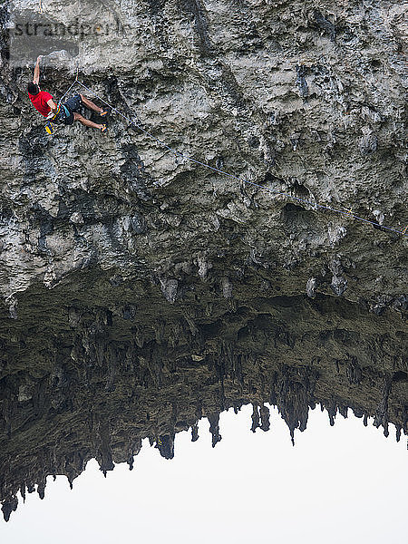 Mann klettert auf den Bogen am Mondberg in Yangshuo