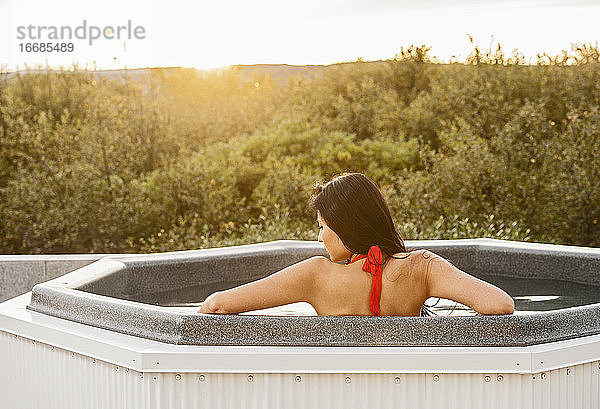 Schöne Frau entspannt im Whirlpool in einer Ferienvilla in Island