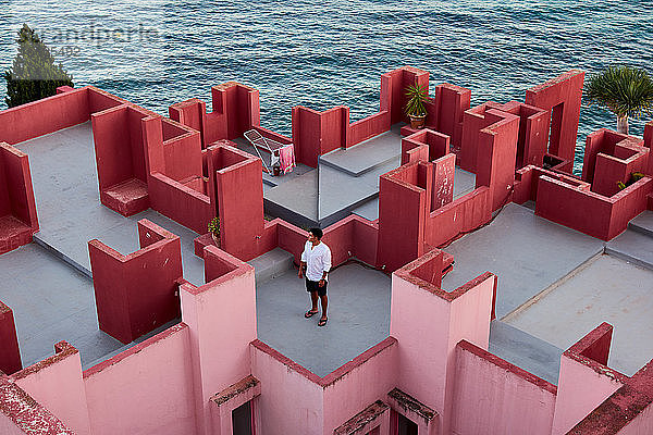 Junger lateinamerikanischer Mann meditativ in 'Muralla Roja' aus Calpe  Spanien