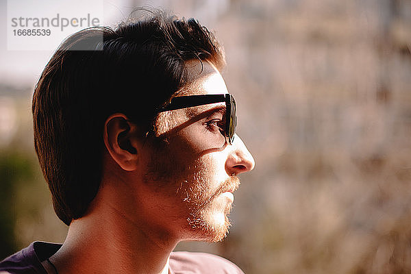 Nahaufnahme eines jungen depressiven Mannes mit Sonnenbrille