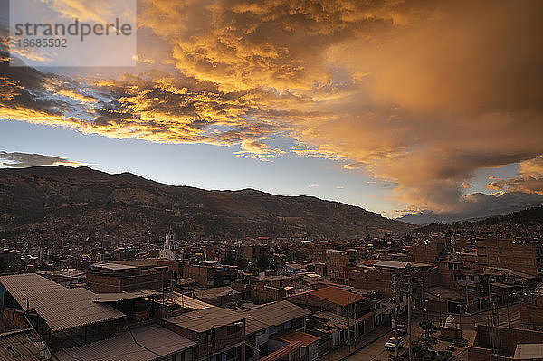 Orangefarbene Wolken bei Sonnenuntergang über Huaraz und der Cordillera Blanca