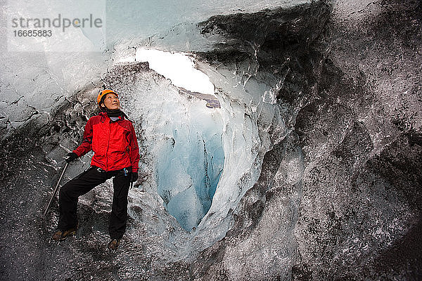 Frau erkundet Eishöhle auf dem Sólheimajökull-Gletscher in Südisland