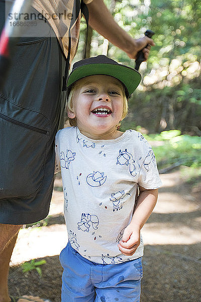 Porträt eines glücklichen Jungen beim Wandern mit seinem Vater.