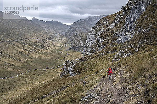 Eine Person mit roter Jacke beim Wandern auf dem Huayhuash-Rundweg