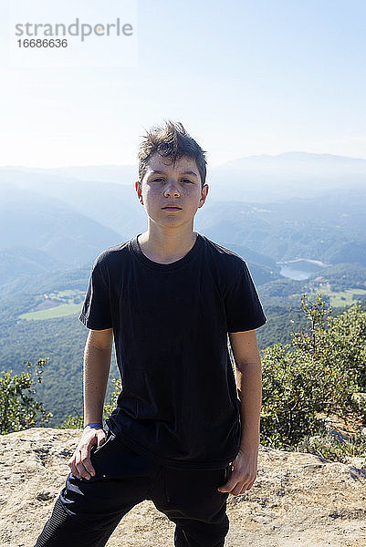 Porträt eines jungen Mannes mit schwarzem T-Shirt vor einem Gebirge