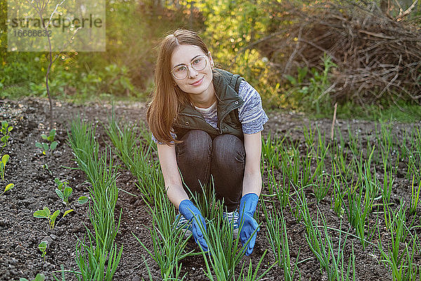 Frau arbeitet auf dem Boden und baut biologische Pflanzen  Obst und Gemüse an