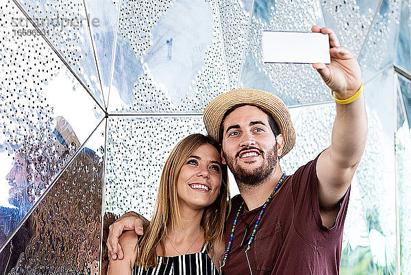 Glückliches Paar nimmt Selfie auf der Straße während der Ferien Reise