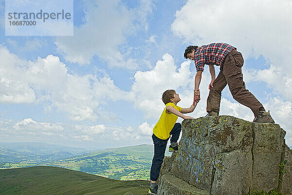 Jugendlicher hilft seinem Freund beim Klettern