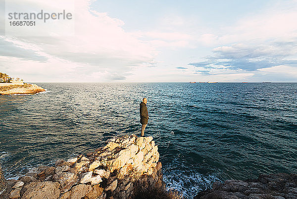 Aufnahme eines Mannes in der Mitte einer dem Meer zugewandten Landschaft