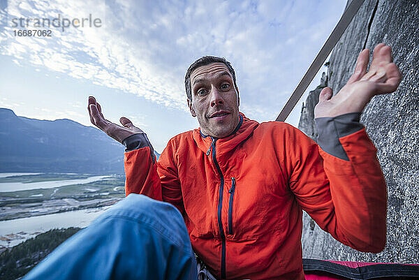 Mann mit überraschtem Blick beim Verhör auf dem Portaledge bei Sonnenuntergang