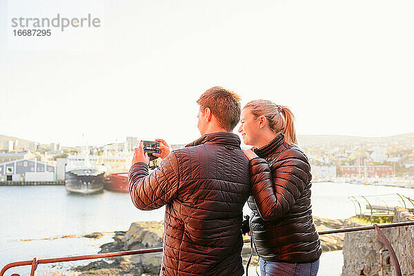 Pärchen fotografiert Boote im Hafen