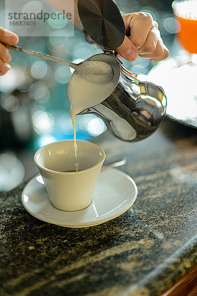 Hände einer jungen erwachsenen kaukasischen Barista-Frau bei der Arbeit