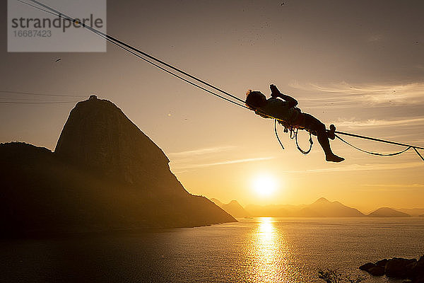 Schöne Sonnenaufgang Blick auf Mann zu Fuß auf Highline mit Zuckerhut