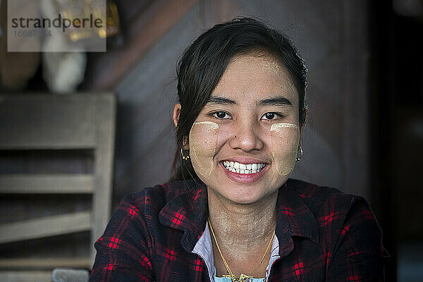 Porträt einer lächelnden jungen birmanischen Frau mit Thanaka im Gesicht  Bagan  Myanmar