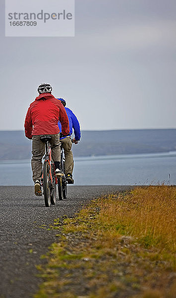 zwei Freunde fahren mit ihren Mountainbikes um den Thingvellir-See