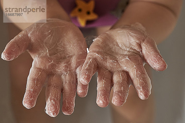 Kinderhände in seifigem Schaum. Das Konzept des Händewaschens  der Hygiene. Schutz vor Pandemien. Prävention