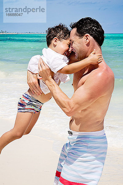 Vater und Sohn spielen am Strand in der Karibik