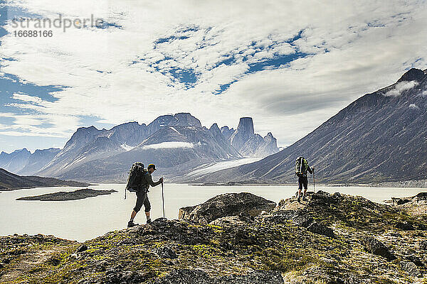 Rucksacktouristen überqueren einen Bergkamm am Akshayak-Pass auf Baffin Island.