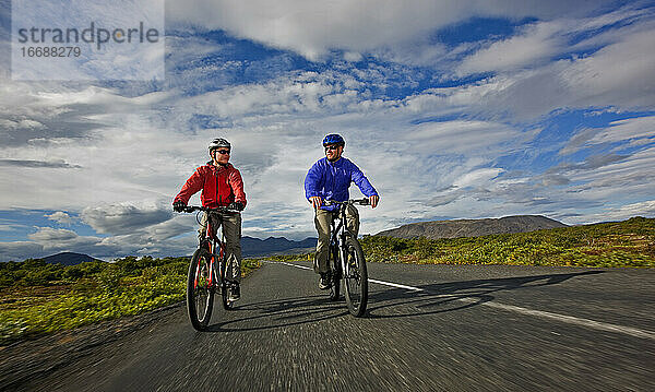 zwei Freunde fahren mit ihren Mountainbikes um den Thingvellir-See