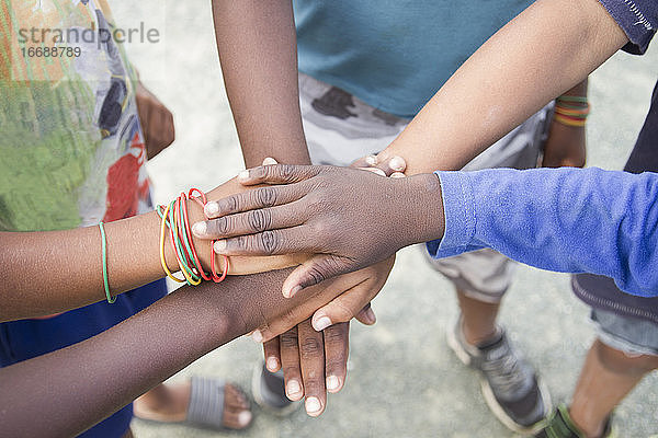 anonyme Gruppe von Kindern verschiedener Rassen  die sich in einer natürlichen Umgebung im Freien die Hände reichen - Konzept der Zusammengehörigkeit