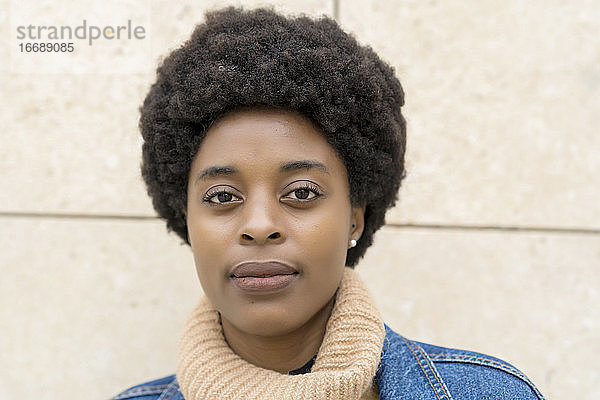 Fotografie von eleganter afrikanischer Frau mit Afro-Haar und blauer Windjacke