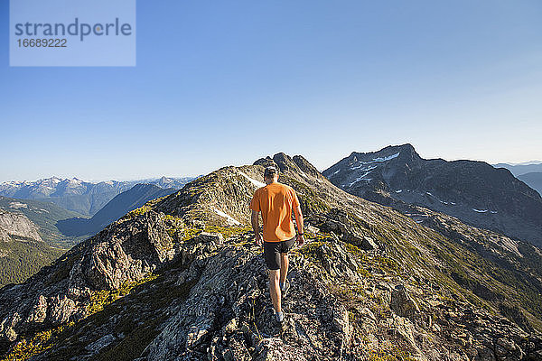 Rückansicht eines Mannes beim Trailrunning auf einem Bergkamm  B.C.  Kanada.