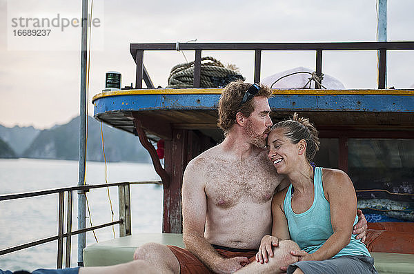 mittleres erwachsenes Paar entspannt sich auf einem Boot in der Halong-Bucht in Vietnam