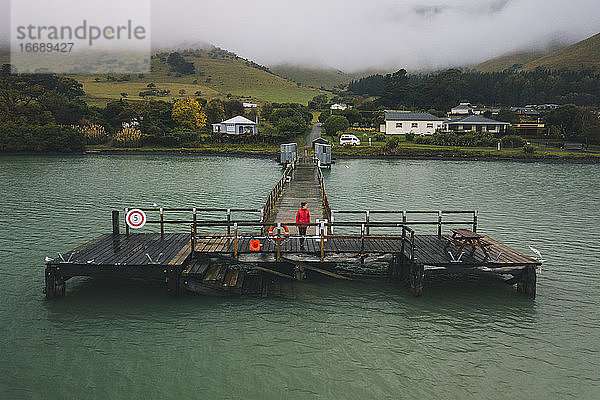 Frau in einer roten Jacke am Port Levy Jetty  Banks Peninsula  Neuseeland