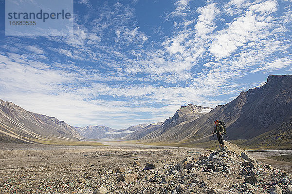 Rucksacktourist betrachtet die Landschaft von der Spitze einer Gletschermoräne aus.