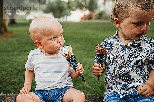 Junges weißes Kleinkind und Baby essen Eiscreme im Sommer