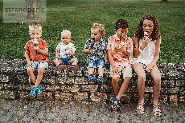 Weiße Familie und Kinder essen in den Ferien gemeinsam Eiscreme