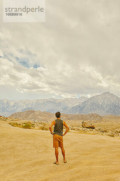 Junger Mann in der kalifornischen Wüste mit Blick auf die Berge von Alabama Hills.