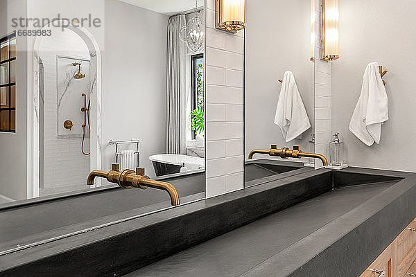 Badezimmer in einer Luxuswohnung mit Betonwaschbecken und Doppelwaschtisch
